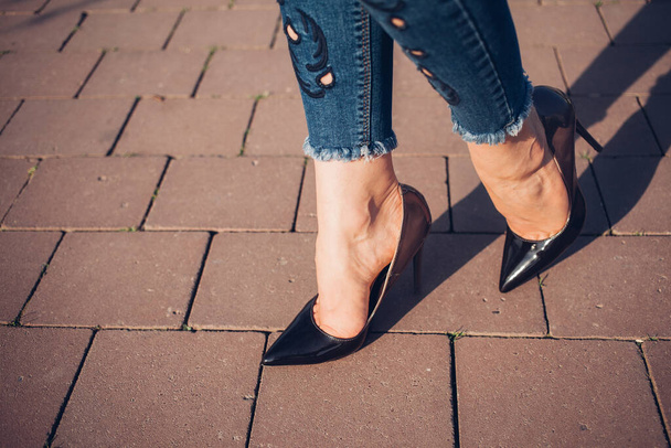 Γυναίκα με μαύρα ψηλά τακούνια. Κοντινό πλάνο των γυναικείων ποδιών σε ψηλά τακούνια - Φωτογραφία, εικόνα