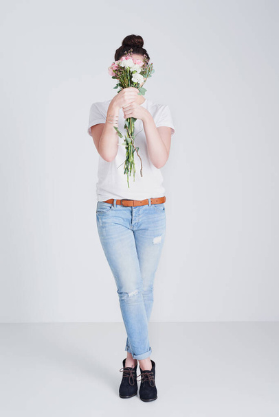 Fiorisca con la Sua fiducia. Studio foto di una donna irriconoscibile che tiene un mazzo di fiori su uno sfondo grigio. - Foto, immagini