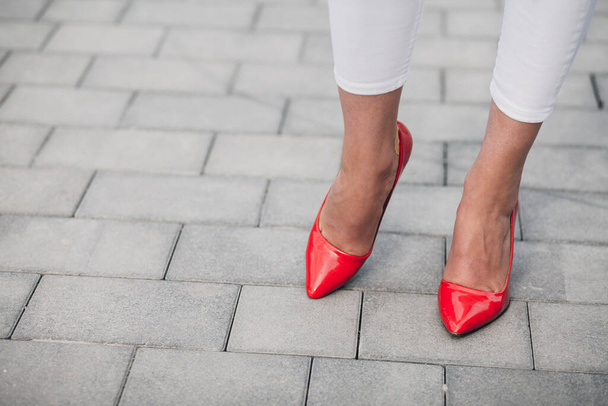 Egy nő vörös magassarkúban. Női lábak közelsége magassarkúban - Fotó, kép