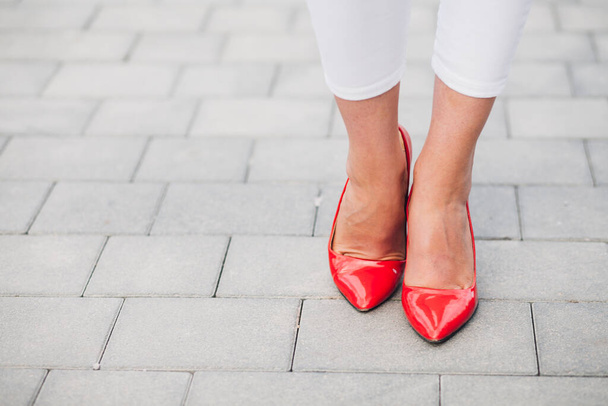 Женщина на красных каблуках. Крупный план женских ног на высоких каблуках - Фото, изображение