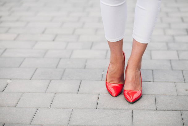 Mujer con tacones rojos. Primer plano de las piernas femeninas en tacones altos - Foto, Imagen