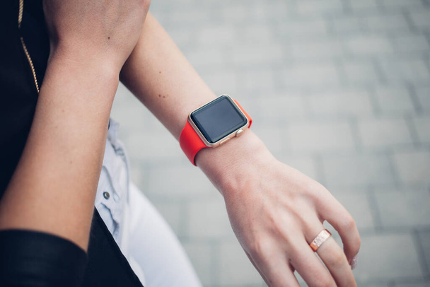 Photo of female hands touching screen generic design smart watch. Film effects, blurred background - Photo, Image