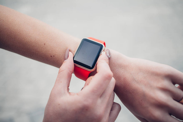 Photo of female hands touching screen generic design smart watch. Film effects, blurred background - Photo, Image