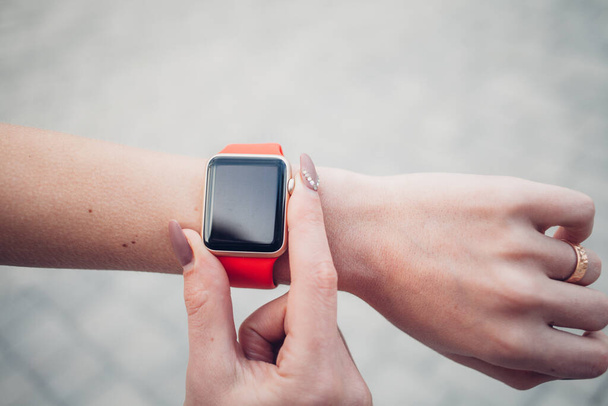 Photo of female hands touching screen generic design smart watch. Film effects, blurred background - Foto, Imagem