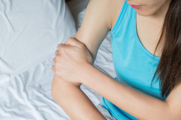 Primo piano della donna con il dolore al braccio. Sofferenza dolorosa causata da lesioni o uso eccessivo. - Foto, immagini
