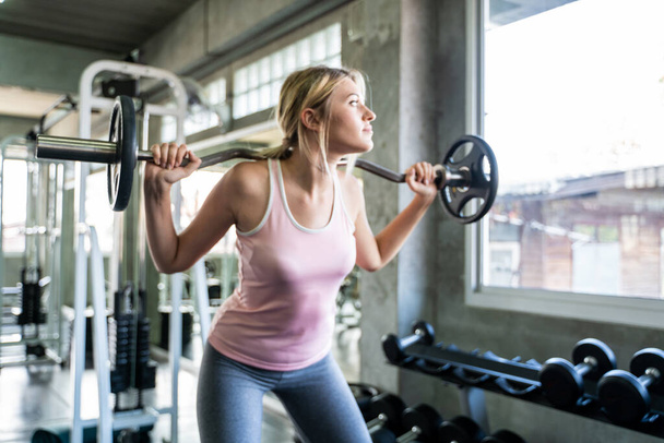 Sport women lift up barbell in fitness gym healthy lifestyle - 写真・画像