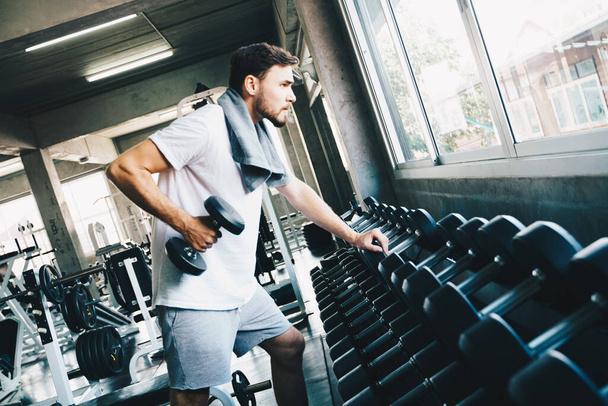 Smart sport homme soulevant haltère dans la salle de fitness wellnes activité main gros plan - Photo, image