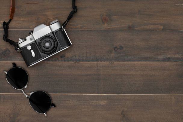 Vintage fotocamera e occhiali da sole su sfondo in legno con spazio di testo libero - Foto, immagini