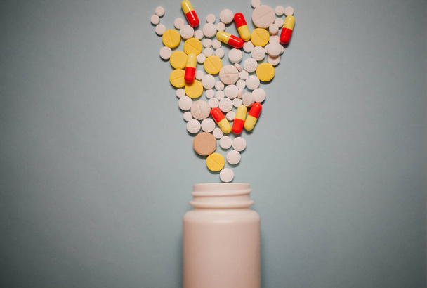 Medicamentos farmacêuticos variados comprimidos, comprimidos e cápsulas e frasco em fundo azul
 - Foto, Imagem