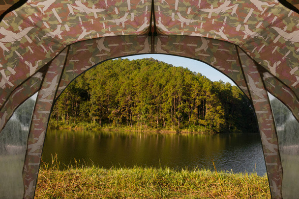 Tenda di vedetta su un campo con foresta sul lago. - Foto, immagini