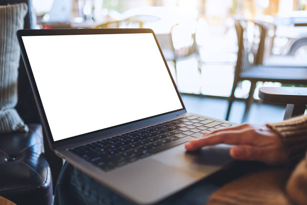 Mockup-Bild einer Frau, die ein Laptop-Touchpad mit leerem weißen Desktop-Bildschirm benutzt und berührt  - Foto, Bild