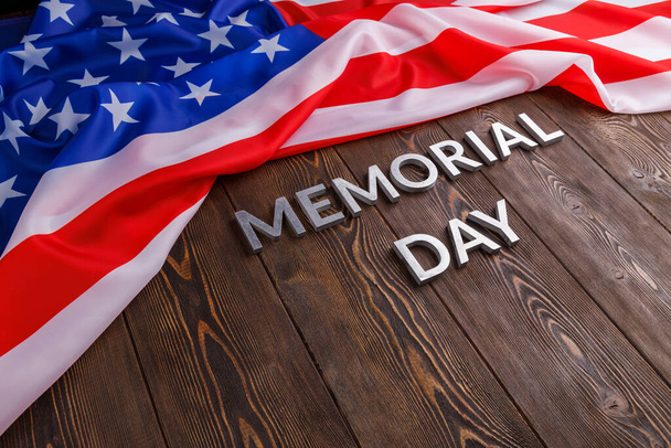 les mots jour commémoratif posé avec des lettres en métal argenté sur la surface de la planche en bois avec drapeau américain froissé - Photo, image