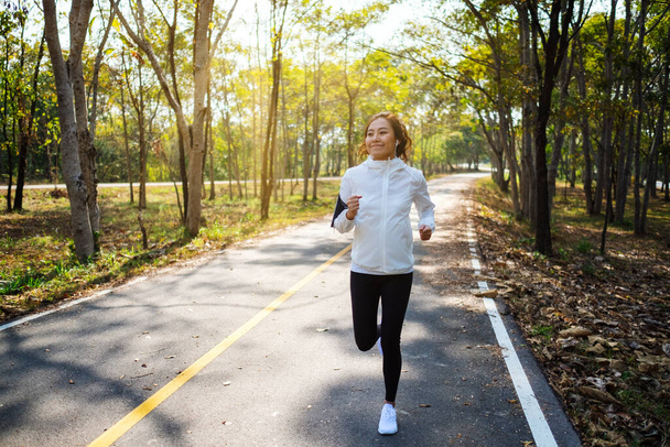 Eine junge Asiatin joggt morgens im Stadtpark - Foto, Bild