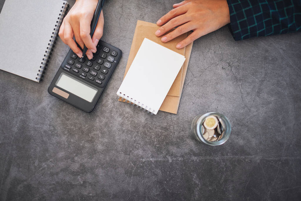 Imagen de vista superior de un hombre de negocios calculando y contando dinero y escribiendo contabilidad financiera en un cuaderno  - Foto, Imagen