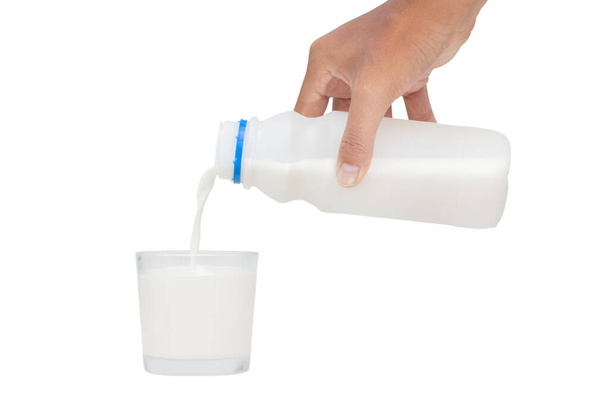 Ρίχνει γάλα σε γυαλί απομονωμένο σε λευκό φόντο - αποκόπτοντας διαδρομές - Φωτογραφία, εικόνα