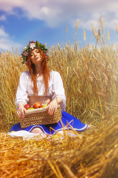 Vöröshajú lány almával, rozs területén - Fotó, kép