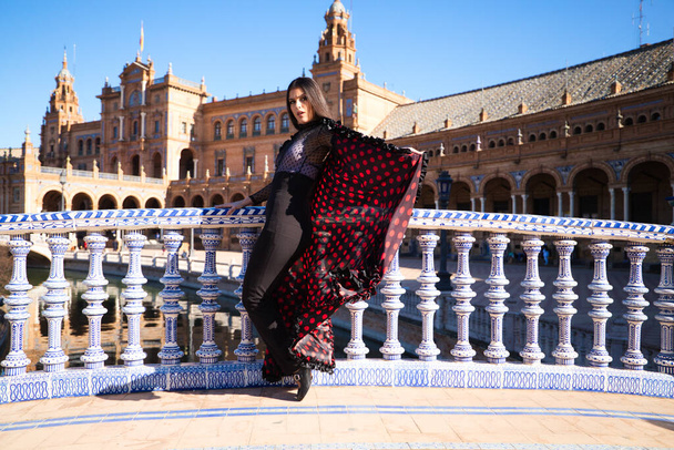 Young and beautiful woman dancing flamenco and Spanish posing in urban clothes, wearing her hair loose and long and standing on the tips of her shoes. flamenco cultural heritage of humanity. - Foto, immagini