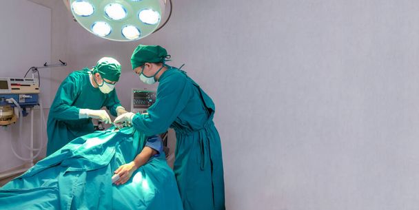 Profissionais cirurgiões inteligentes de pé perto do paciente e realizando uma operação. espaço de cópia - Foto, Imagem