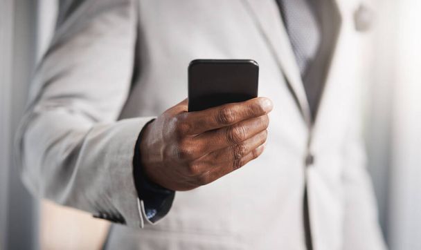 Running business with instant connectivity. Closeup shot of an unrecognizable businessman using a cellphone. - Photo, Image
