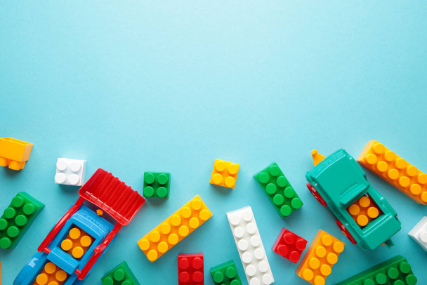 Multicolored blocks of the children's constructor lie on blue background. Top view - 写真・画像