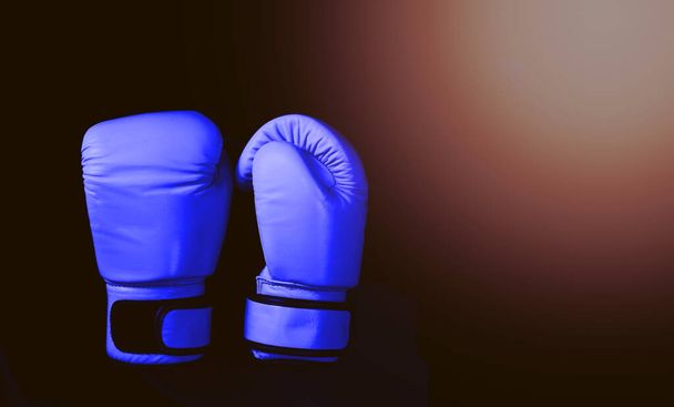 Блакитні боксерські рукавички в спорті на чорному
 - Фото, зображення