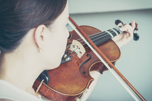女性は音楽家やヴァイオリニストのショー・ストリングのような音楽でバイオリンを演奏します - 写真・画像