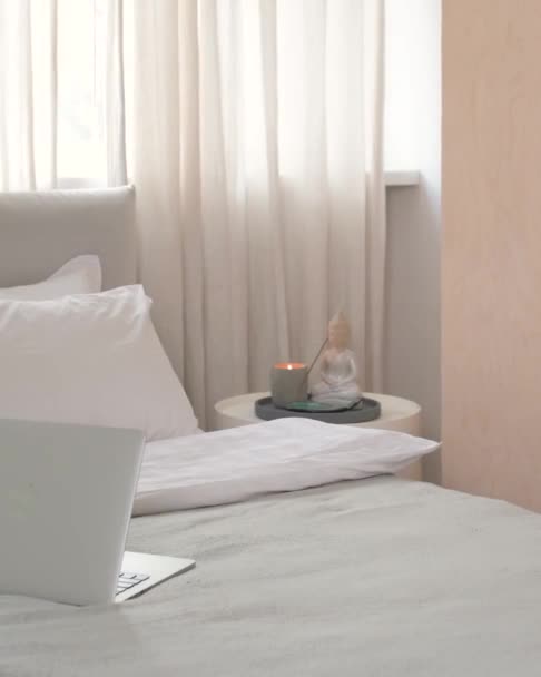 close-up do canto da cama com laptop e mesa com velas e Buda - Filmagem, Vídeo