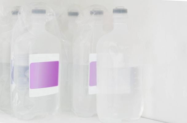 ziekenhuis medische normale zoutoplossing plastic flessen gestapeld op plank voor spoedinjectie chirurgie - Foto, afbeelding