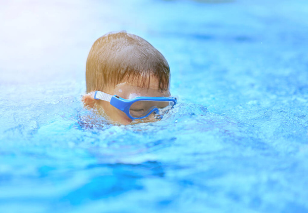 Gözlüklü çocuk yazın havuzda yüzüyor. - Fotoğraf, Görsel