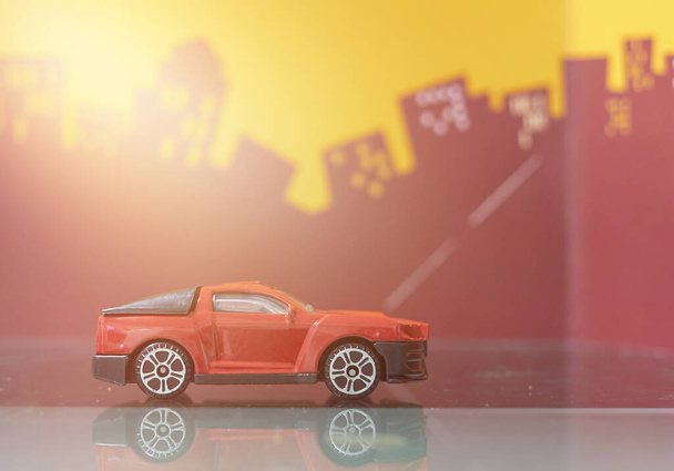 červená hračka auto na pozadí města - Fotografie, Obrázek