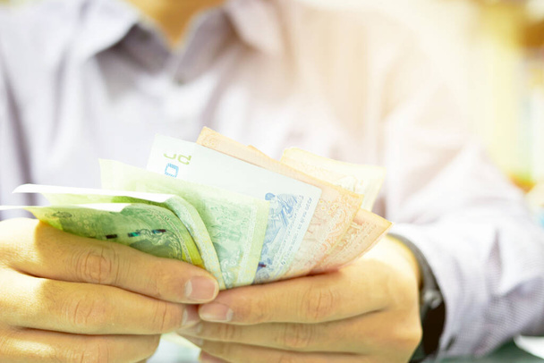 Uniforme man telt Geld bankbiljet voor economische crisis probleem concept - Foto, afbeelding