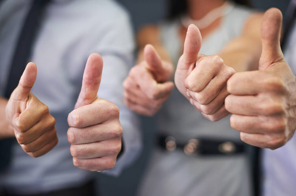 Thats a winning strategy. Closeup shot of a group of professional coworkers giving thumbs up. - Foto, afbeelding