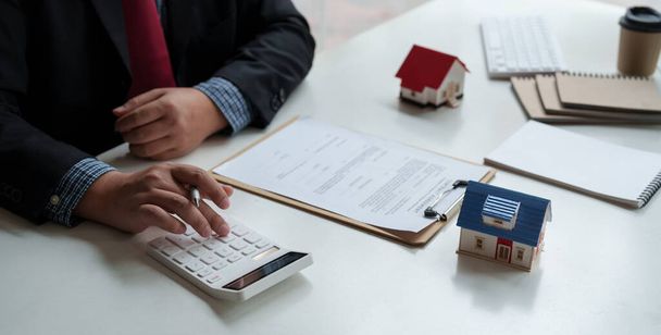 Businessman working doing finances and calculation cost of real estate investment while be signing to contract, Concept mortgage loan approval - 写真・画像