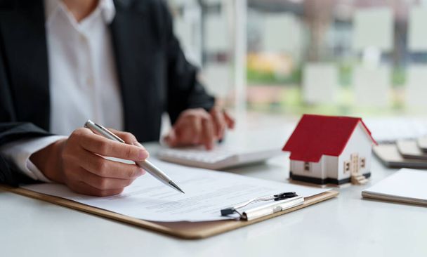 Business woman working doing finances and calculation cost of real estate investment while be signing to contract, Concept mortgage loan approval. - Photo, Image