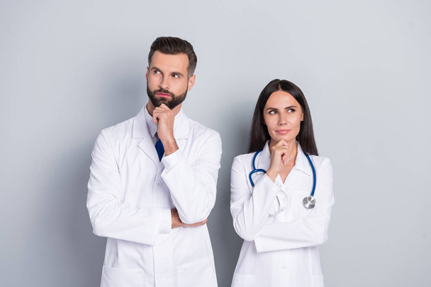 Photo of dreamy clever two docs dressed white coats looking empty space hands arms chins isolated grey color background - Foto, Imagen