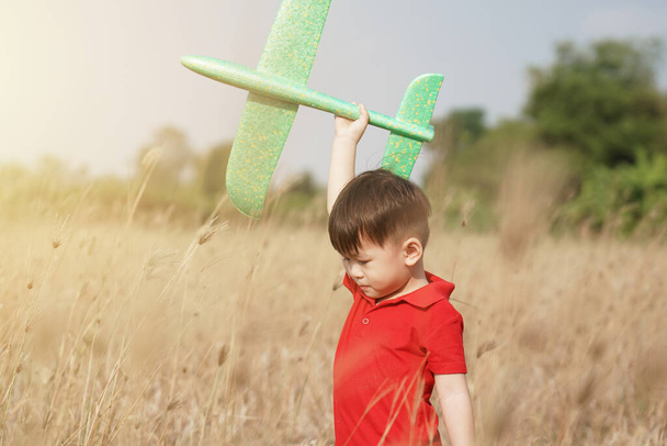 jongen gelukkig spelen met speelgoed vliegtuig in de natuur en heldere ochtend hemel, Kind concept en droom vliegtuig om piloot te worden. willen vliegen als een vliegtuig - Foto, afbeelding