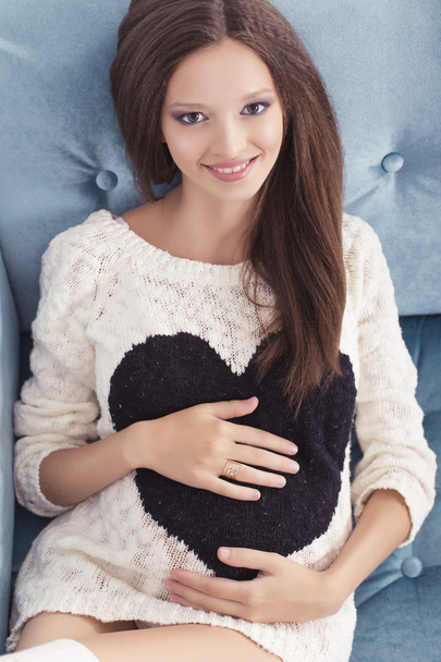 Mooie brunette vrouw op een 7de maand zwangerschap in Wit zweet - Foto, afbeelding