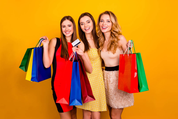 Photo of pretty glamorous ladies sisters in store use plastic contactless credit card bachelorette presents isolated yellow color background - Φωτογραφία, εικόνα