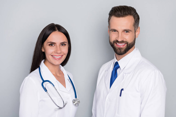 Profile photo of two friendly smart doctors toothy smile look camera isolated on grey color background - 写真・画像