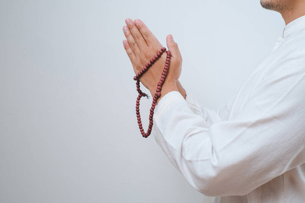 Zamknij Ręcznie trzymając tasbih lub paciorki modlitewne na białym tle - Zdjęcie, obraz