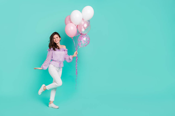 Full body photo of nice cheerful person arm hold air balloons toothy smile isolated on teal color background - Fotografie, Obrázek