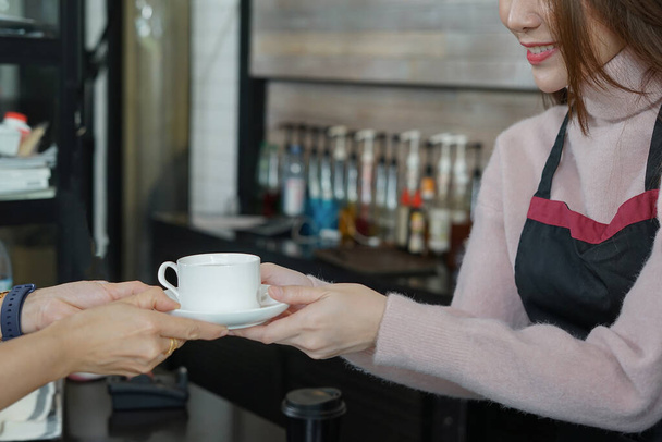 kelnerka serwująca gorącą kawę klientowi           - Zdjęcie, obraz