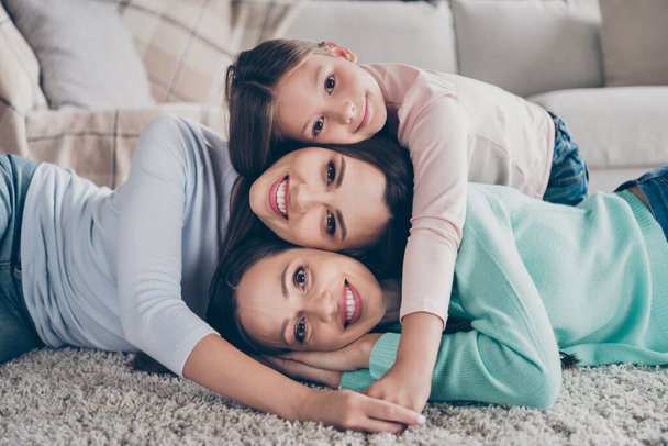 Portrait of attractive sweet cheerful family lying on floor enjoying homey having fun cuddling spending time at home indoors - Foto, imagen