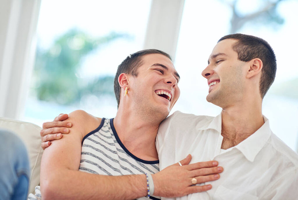 Our home is filled with love and laughter. Shot of a gay couple relaxing together at home. - Photo, Image