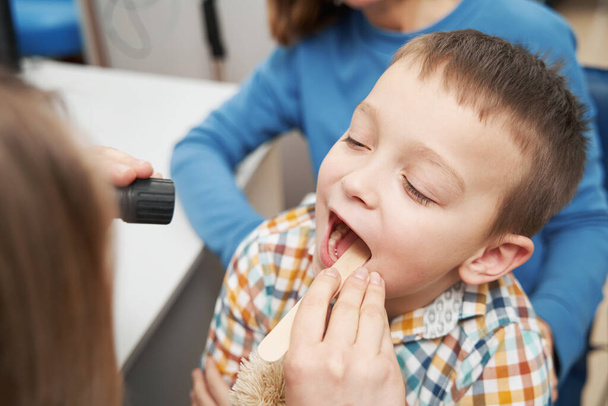 Doctor examining throat of little boy in clinic - Foto, Imagem
