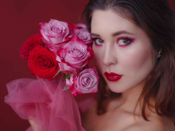 Attractive brunette asian woman with beautiful bouquet of flowers. Pretty woman with bright makeup. Art portrait with roses. Youth and skin care concept - Fotografie, Obrázek