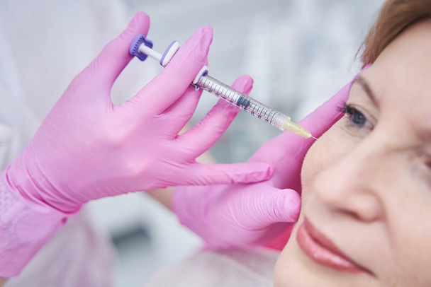 Close up of cosmetologist doing anti-age injection - Foto, imagen
