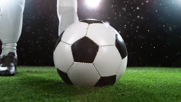 Soccer player legs, ready to kick the ball. Dark scene with spot lights on background. - Fotografie, Obrázek