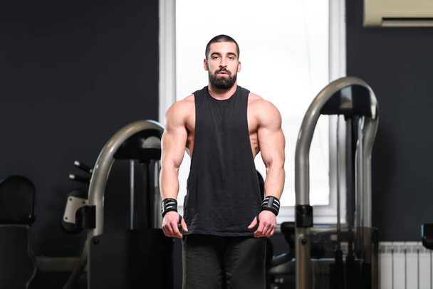 Nuoren fyysisesti sopivan miehen muotokuva, joka näyttää hyvin koulutetun ruumiinsa lihaksikas urheilullinen kehonrakentaja Fitness-mallin poseeraus harjoitusten jälkeen - Valokuva, kuva