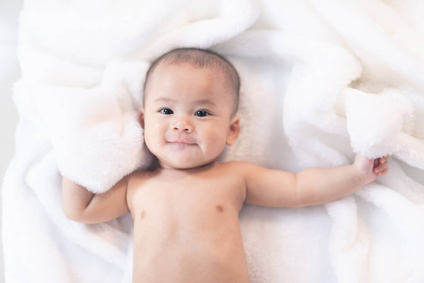 Asyalı bebek yatakta uyuyor. Kürk yatağında portre bebek stüdyosu ışıklandırması. Bebek aile kavramı - Fotoğraf, Görsel